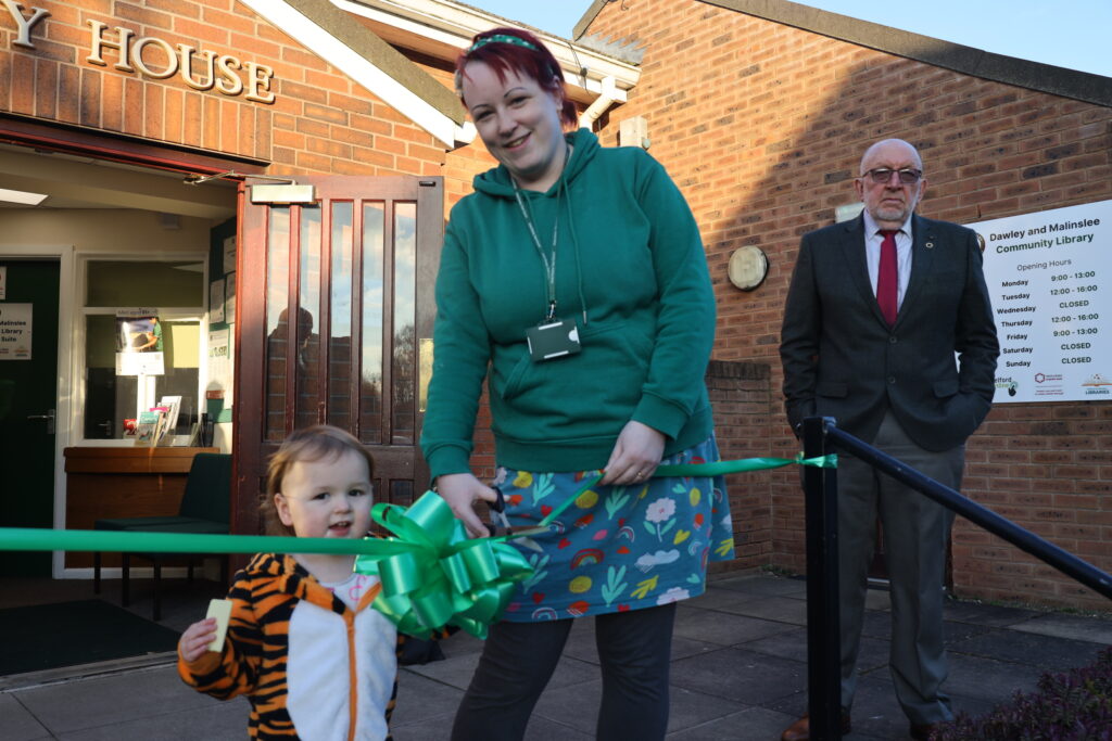 Cllr Lyndsey Parker, with the support of Tilly, cuts the ribbon on the relaunched Dawley & Malinslee Community Library
